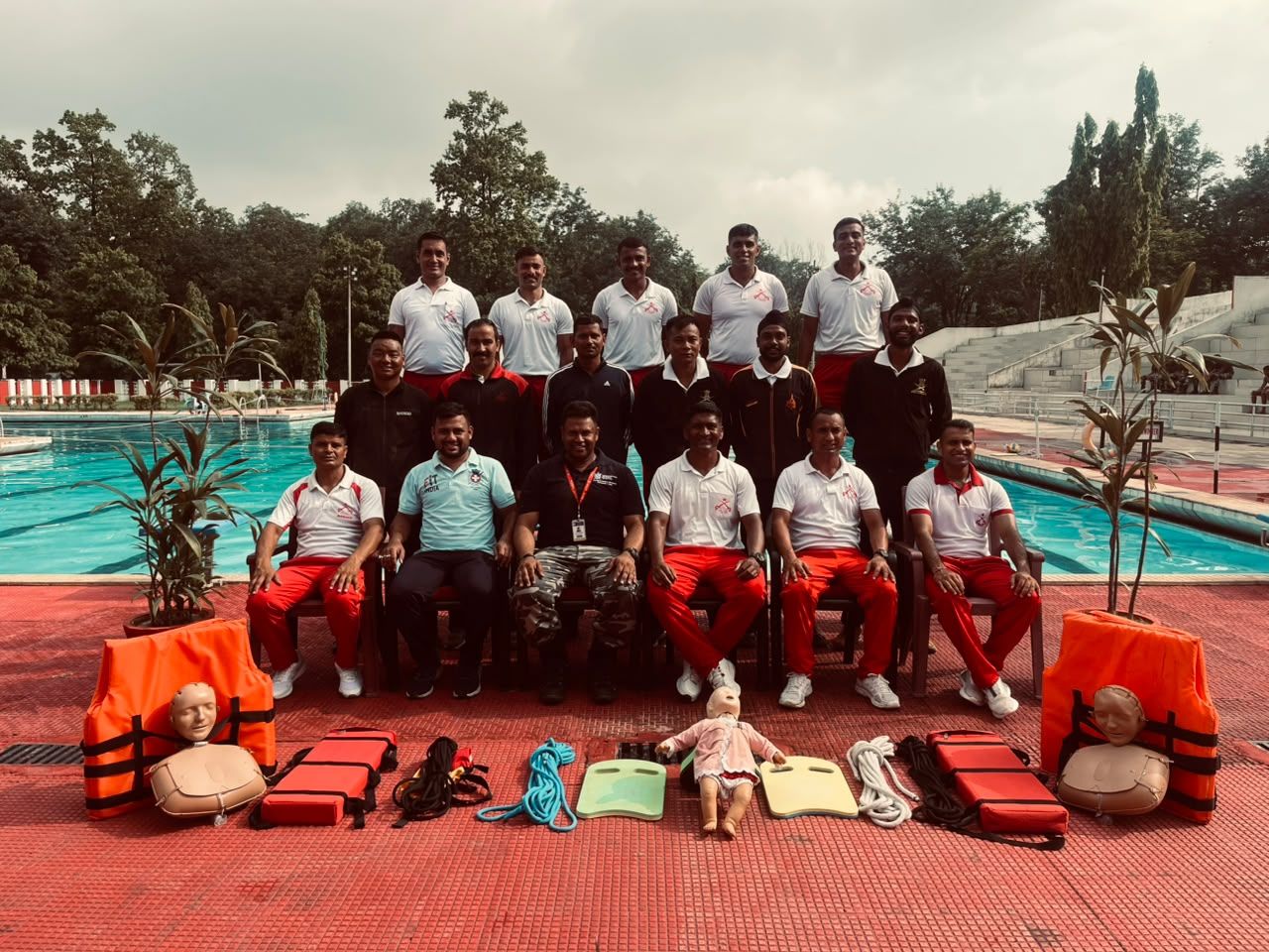 Lifeguard trainees with rescue equipment at a pool