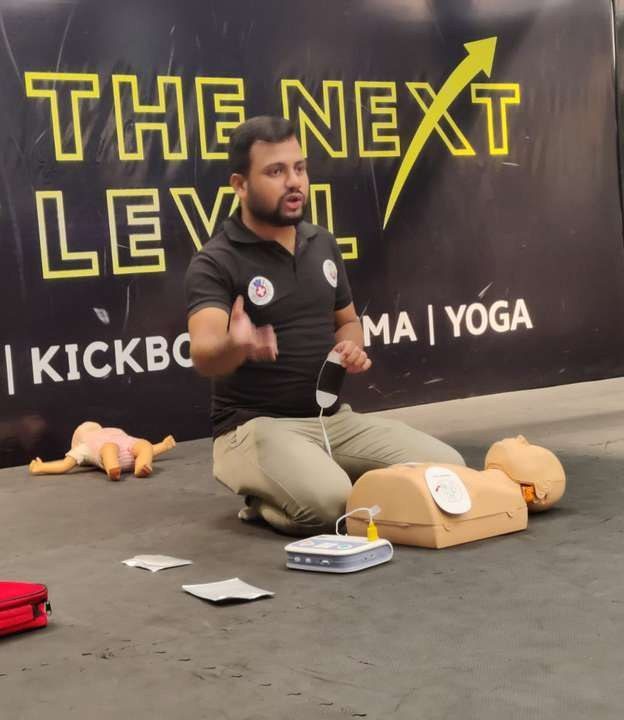 A trainer demonstrating an AED on a manikin