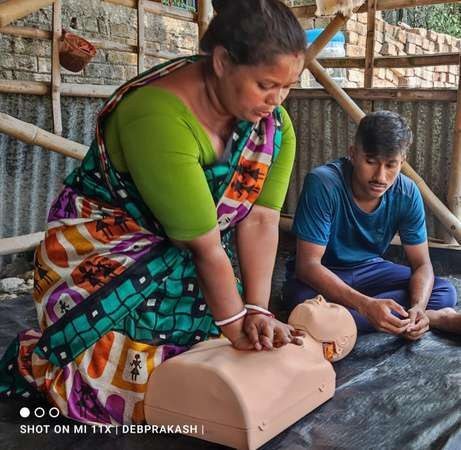 A woman practising CPR on a manikin
